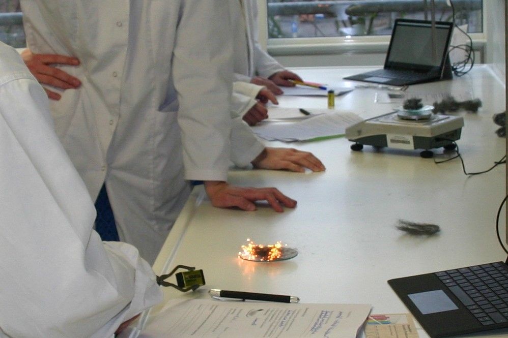 Schülerlabor (Blick auf Experiemntiertisch mit glühender Eisenwolle), Foto: Institut für Didaktik der Chemie