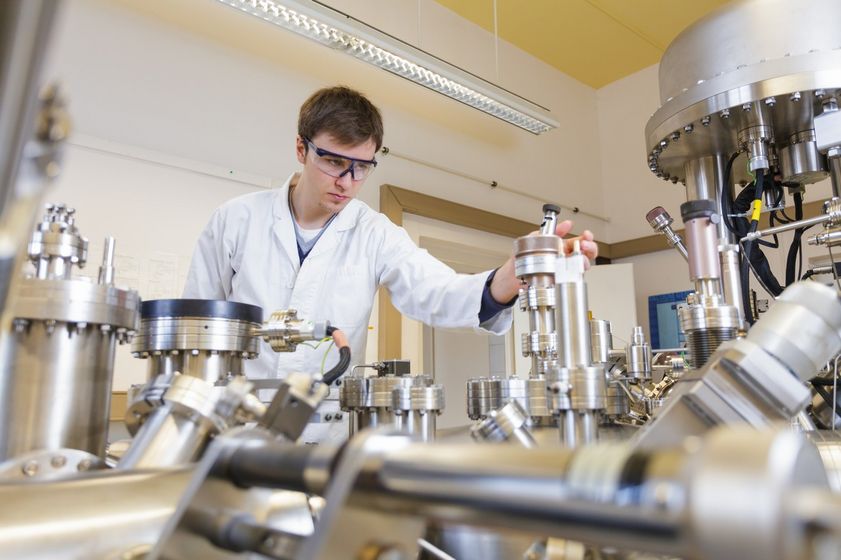 Student im weißen Kittel überprüft Substanz und arbeitet mit Laborgeräten, Foto: Christian Hüller